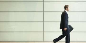 Businessman Striding Down Office Corridor