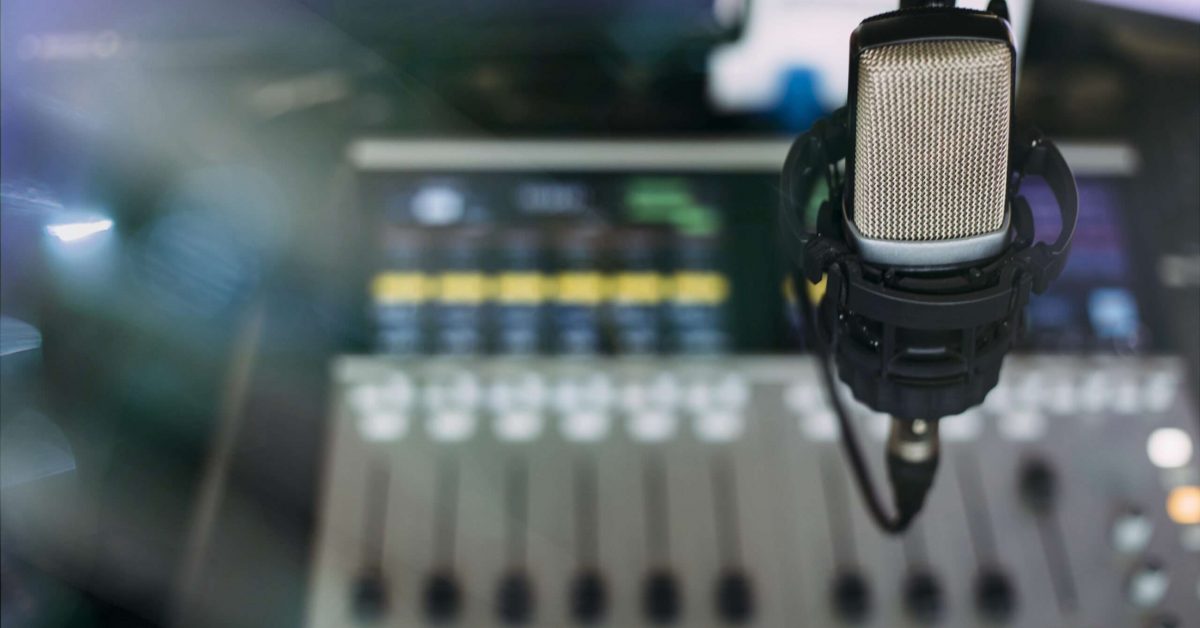 Close up of microphone on radio broadcast studio and sound mixing console on the background