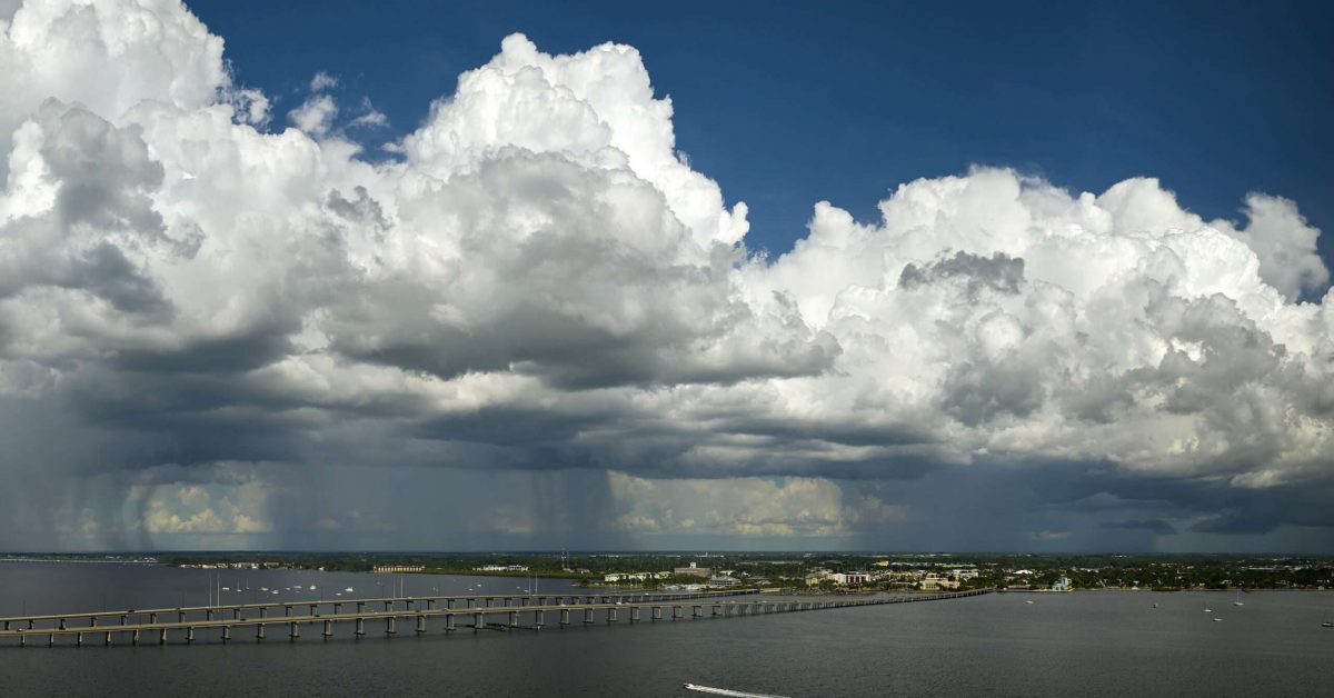 Heavy thunderstorm approaching traffic bridge connecting Punta Gorda and Port Charlotte over Peace River. Bad weather conditions for driving during rainy season in Florida