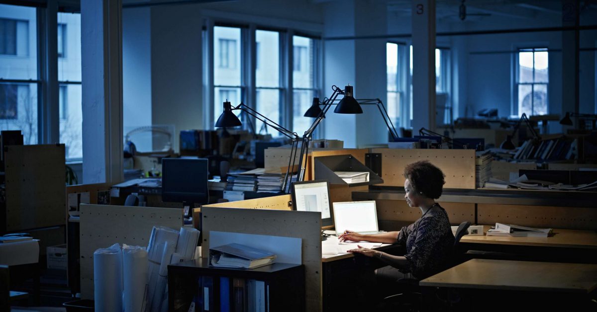 Businesswoman examining documents at desk at night