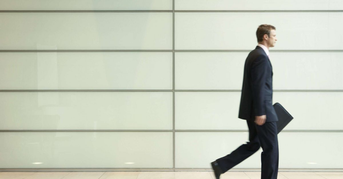 Businessman Striding Down Office Corridor