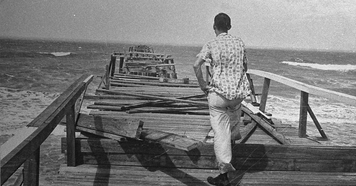 Miami Herald photographer, Doug Kennedy, looks out over the Naples pier, heavily damaged by Hurricane Donna on September 10, 1960